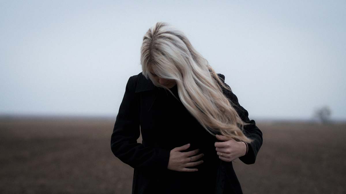 female woman wearing black coat blonde