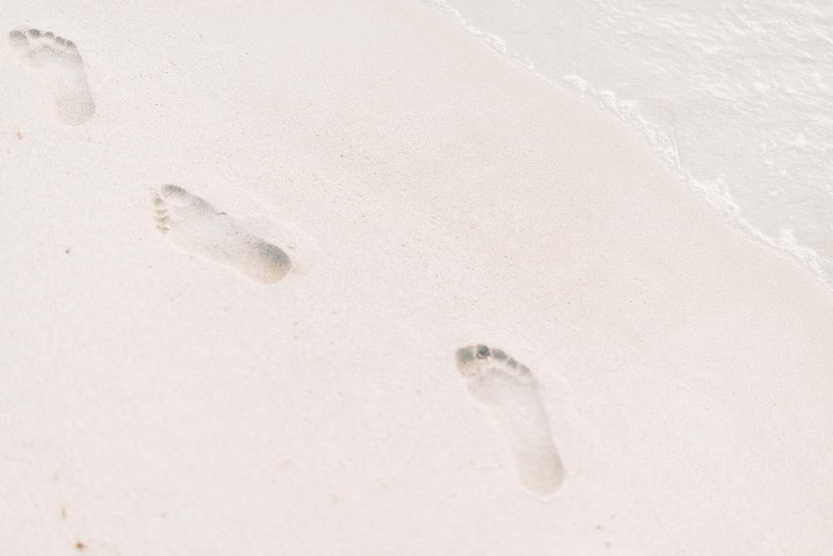 grey photo of foot steps on sand footprint