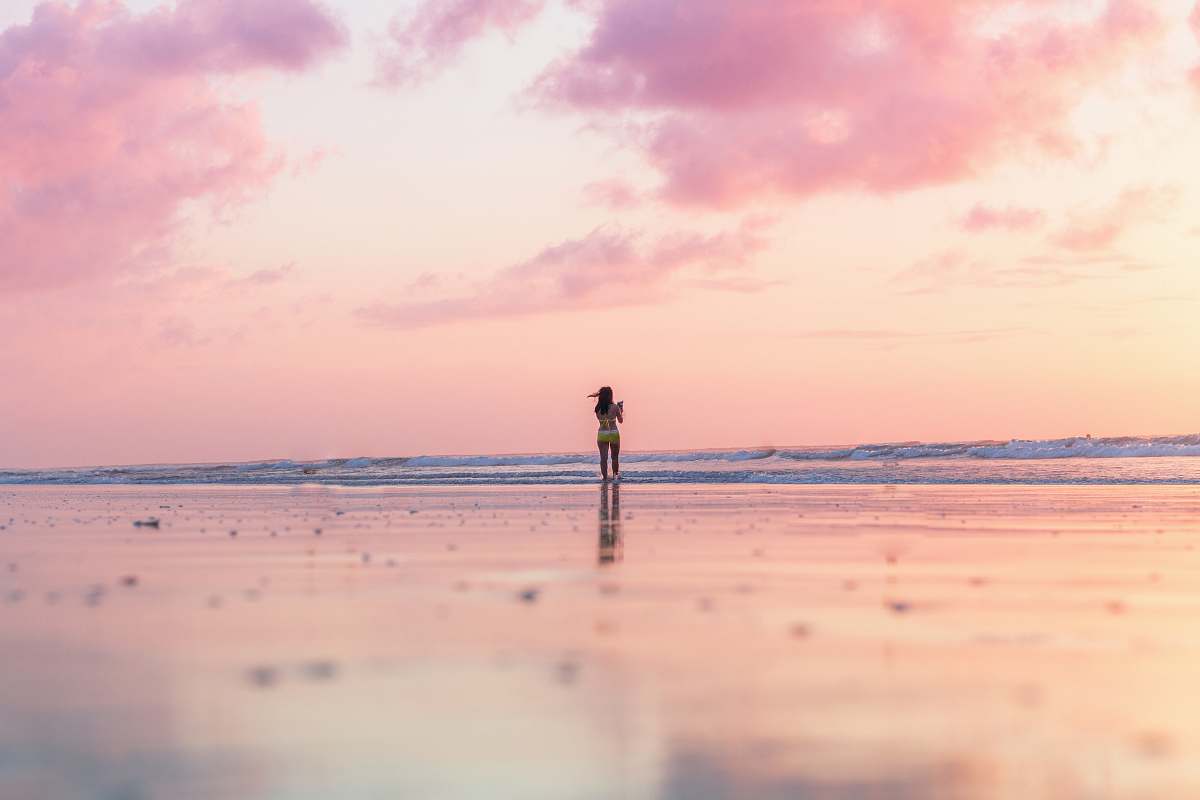 ocean woman standing on seashore in front of body of water coast