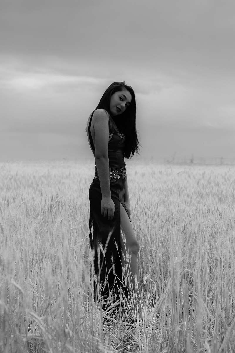 field grayscale photo of woman standing on field apparel