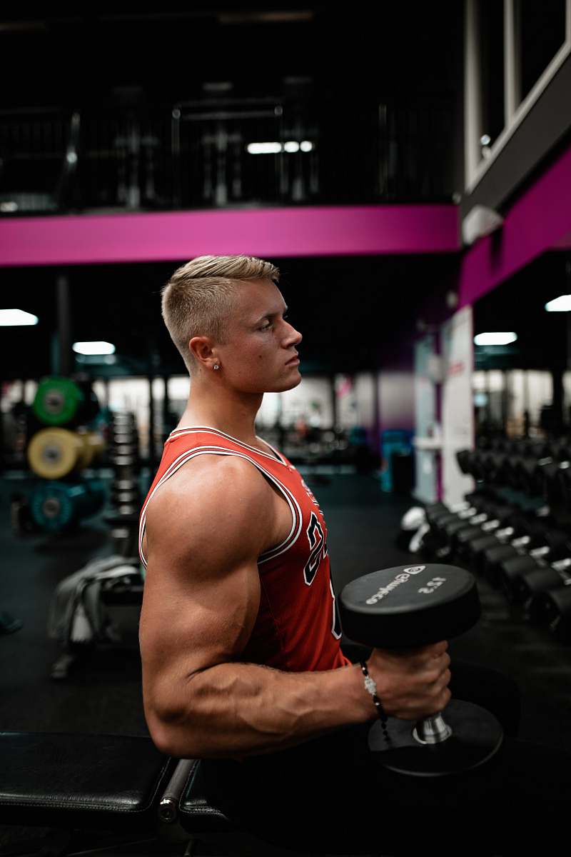 fitness man standing while holding dumbbell inside gym sport
