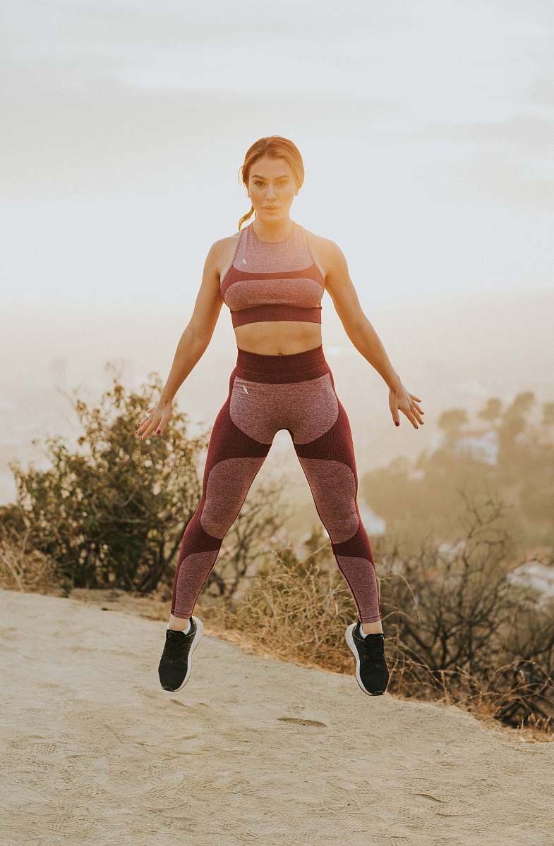 human woman jumping above gray sand people