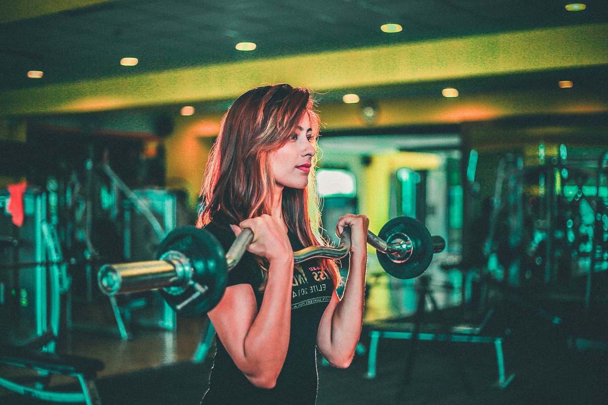 human woman lifting black and gray barbell exercise