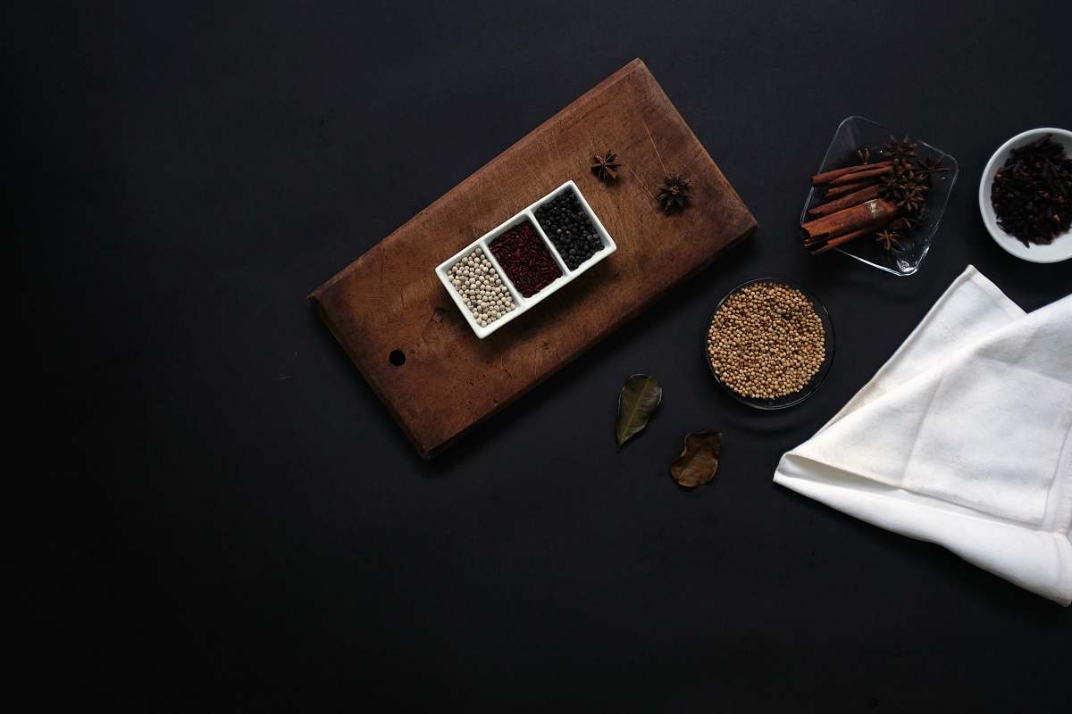 flaylay flat lay photography of beans on brown wooden board beside white handkerchief dark background