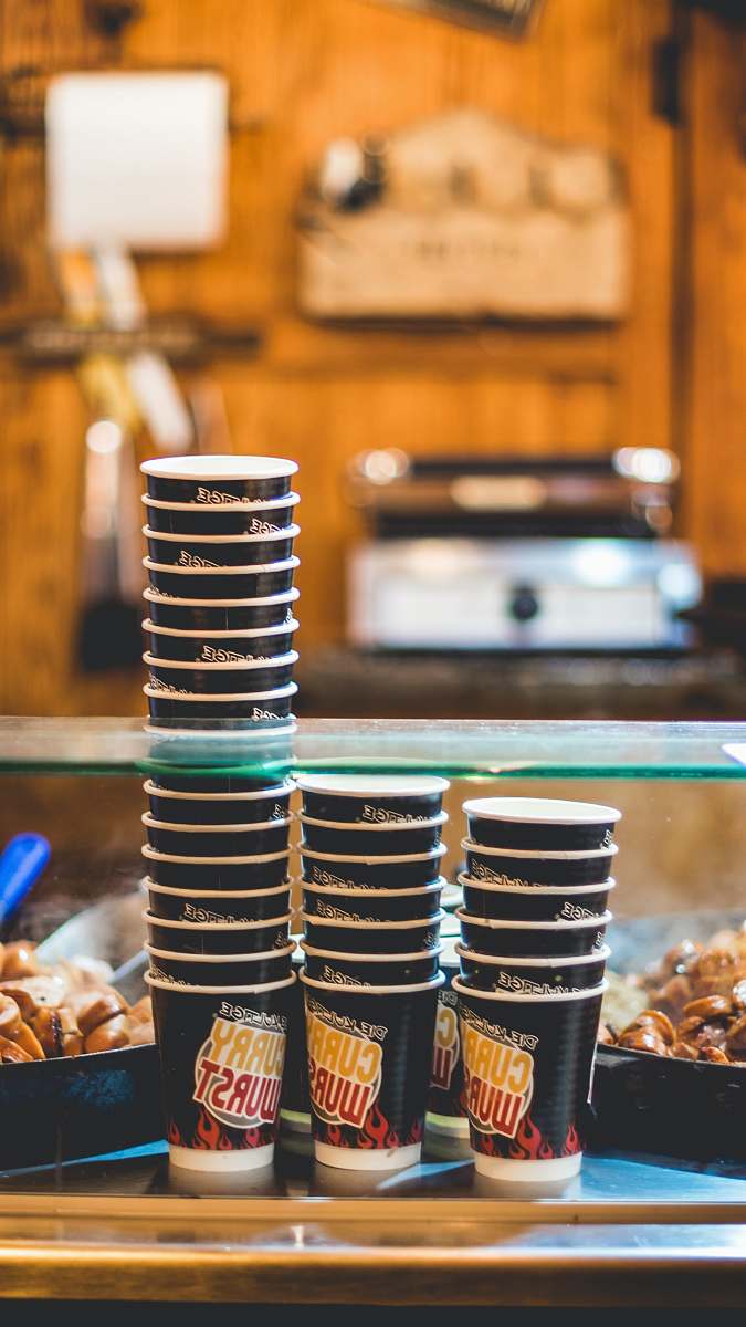 meal three stacks of Curry Wurst disposable cups on gray surface christmas market