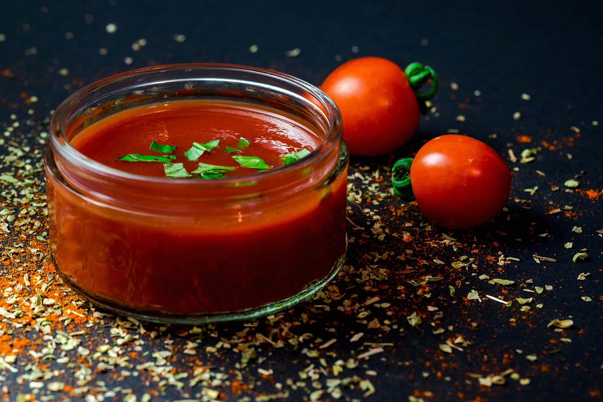 red tomato and tomato puree with parsley in bowl glass