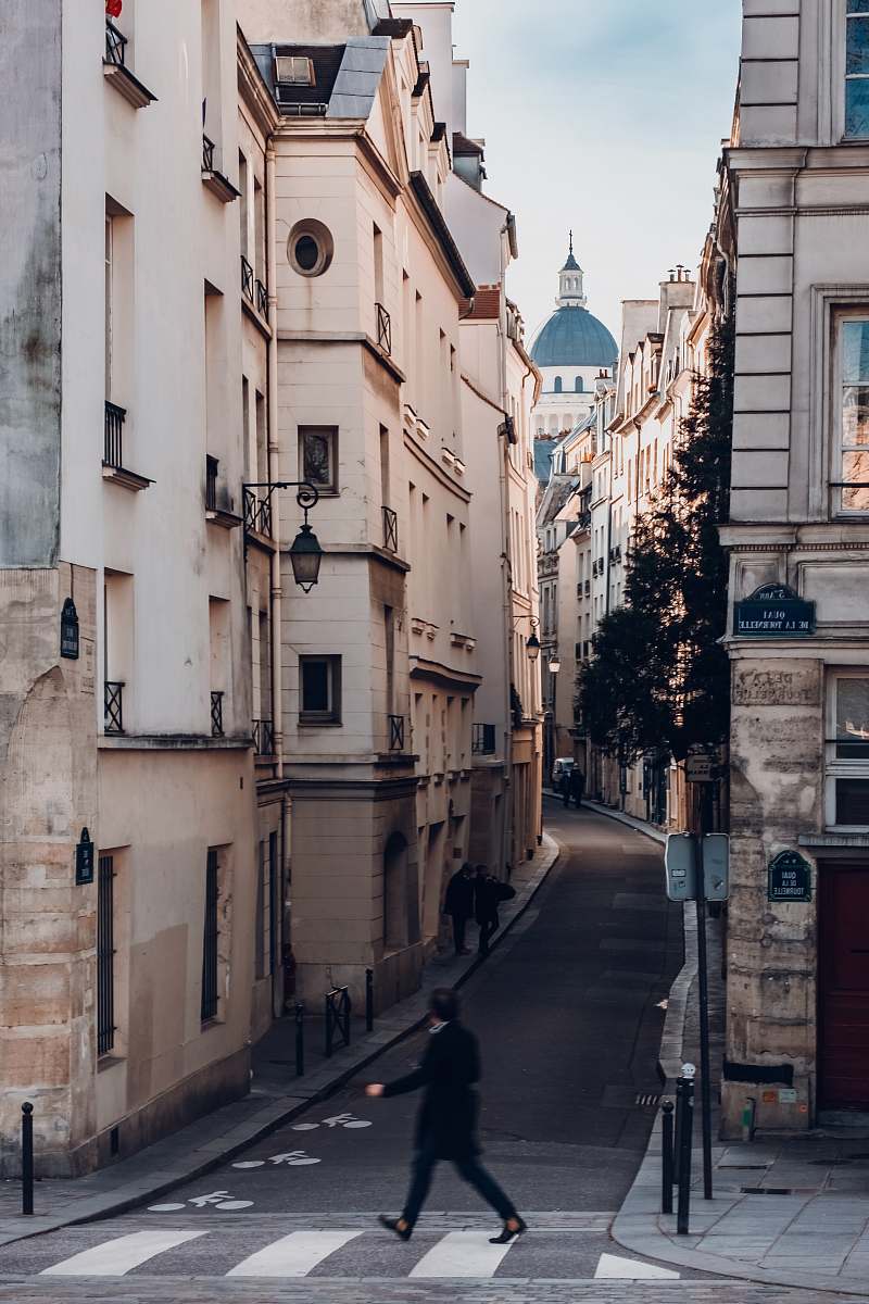 paris photography of person walking on sideway looking at leftside with buildings quai de la tournelle