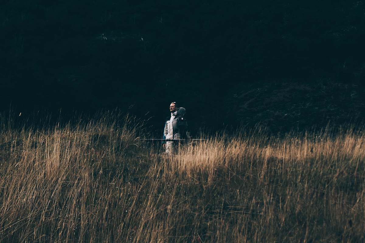 dark person on brown grass at daytime flora
