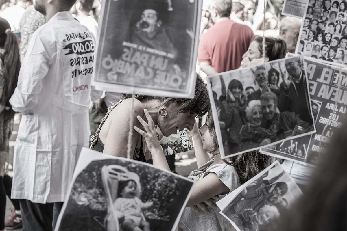 people grayscale photography of woman and girl face to face while covering assorted photos poster
