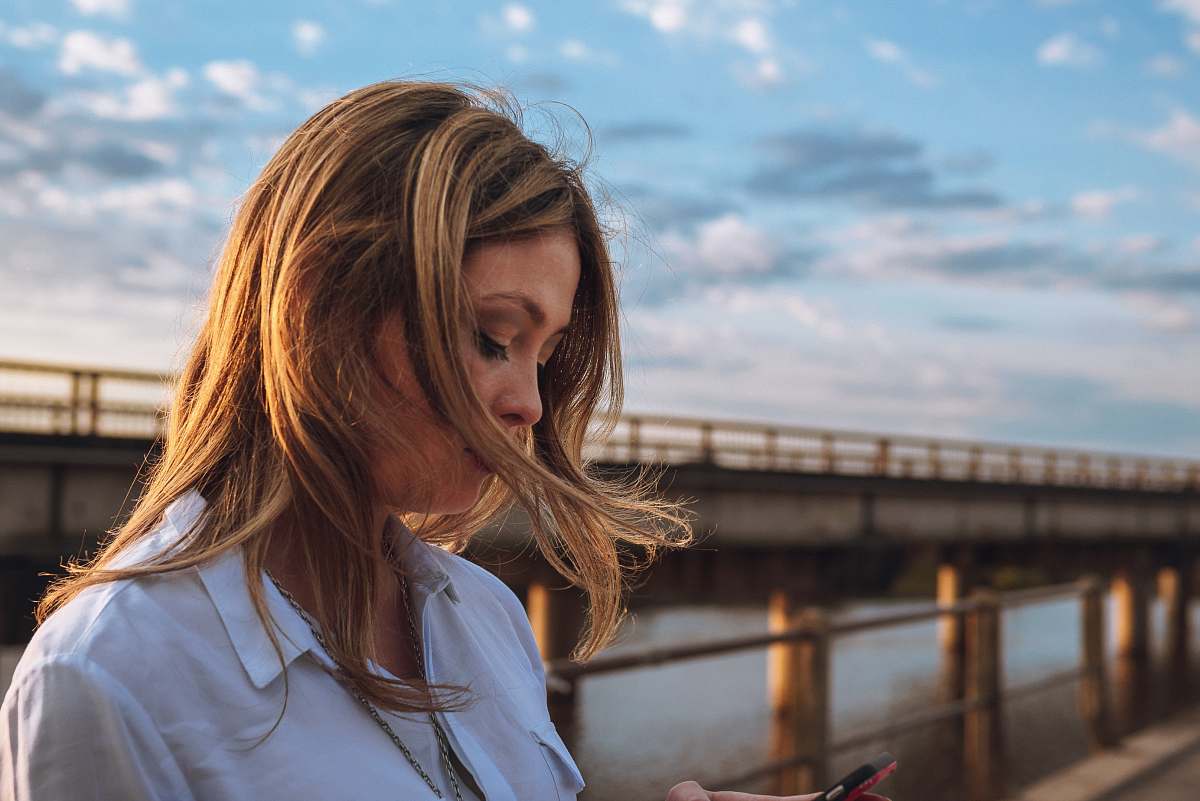 person selective focus photography of on bridge water