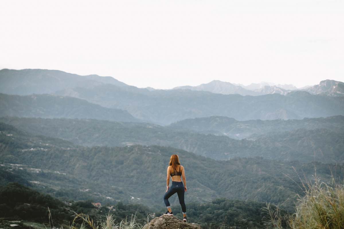 person woman standing on cliff during daytime people