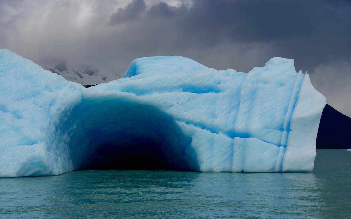 iceberg ice cave on top of body of water ice