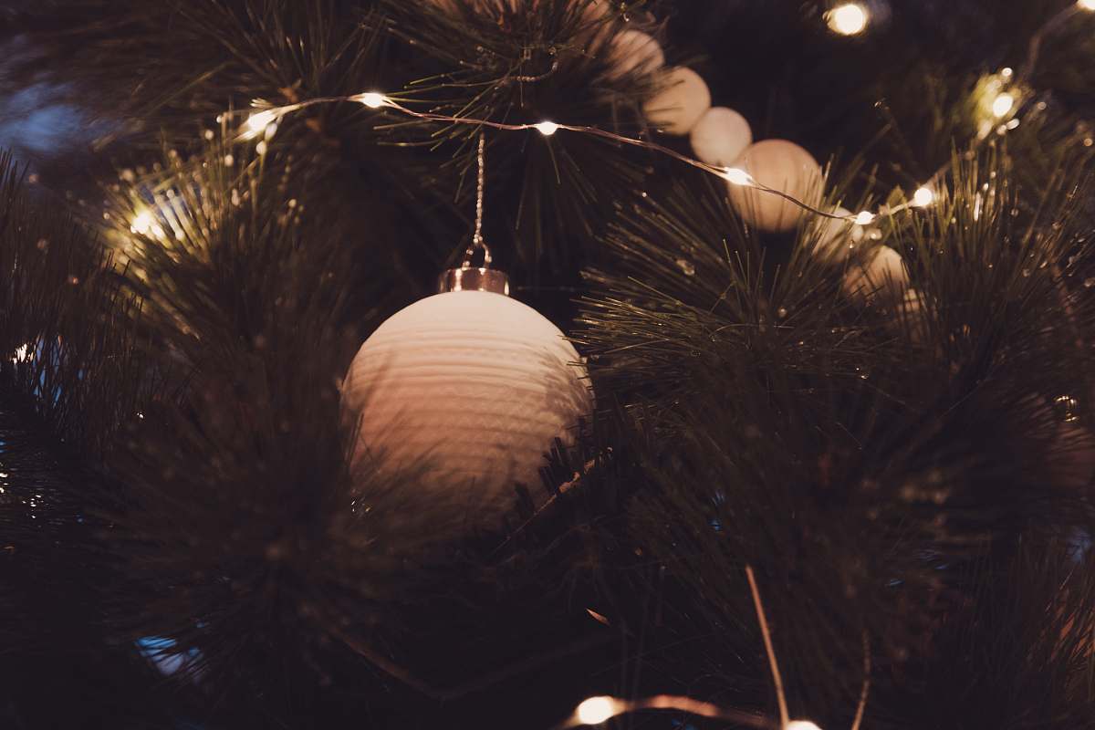 france white bauble in Christmas tree outdoors
