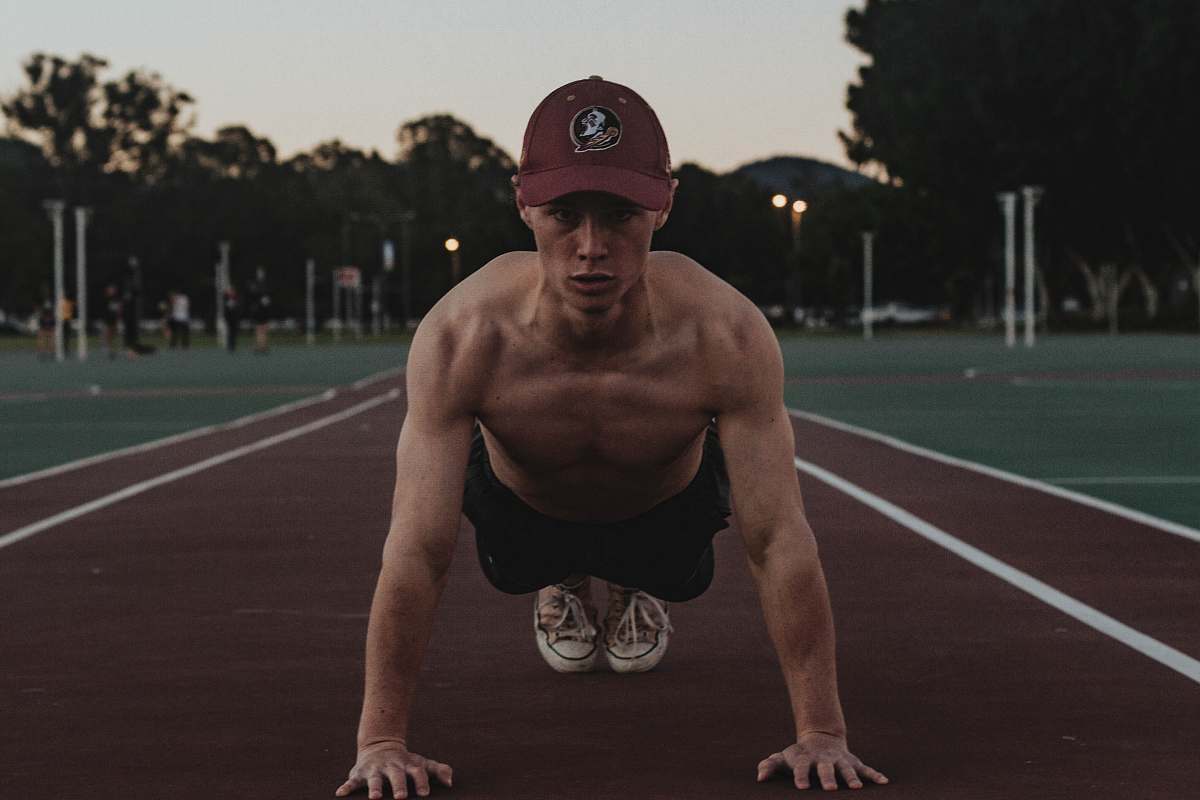 human man doing push-ups on a track field fitness