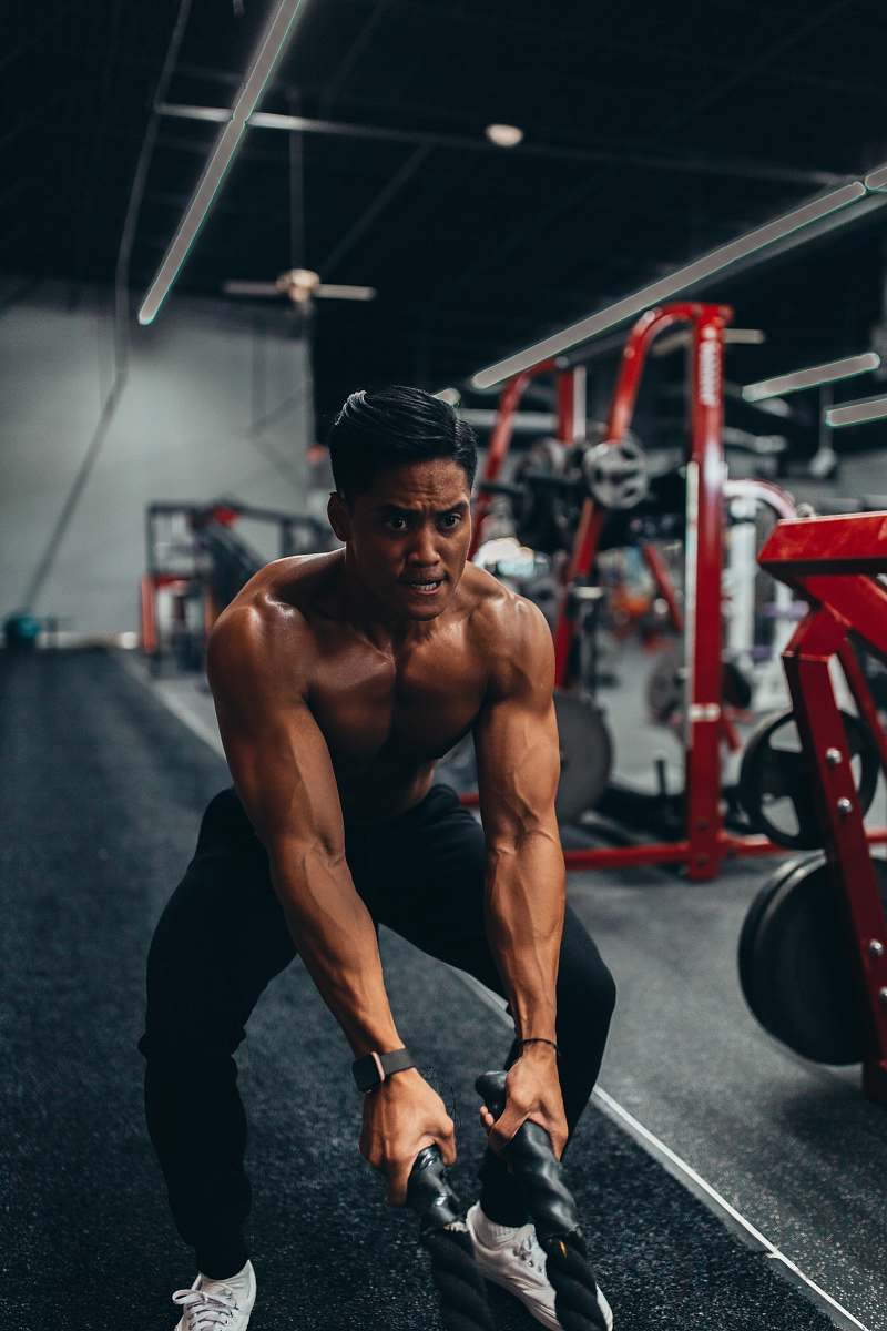 human muscled man holding two black ropes apparel
