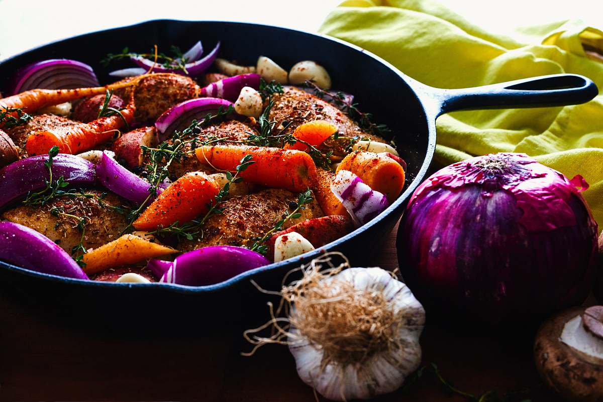 food carrots, garlic, onions, and herb spicing meat on skillet vegetable