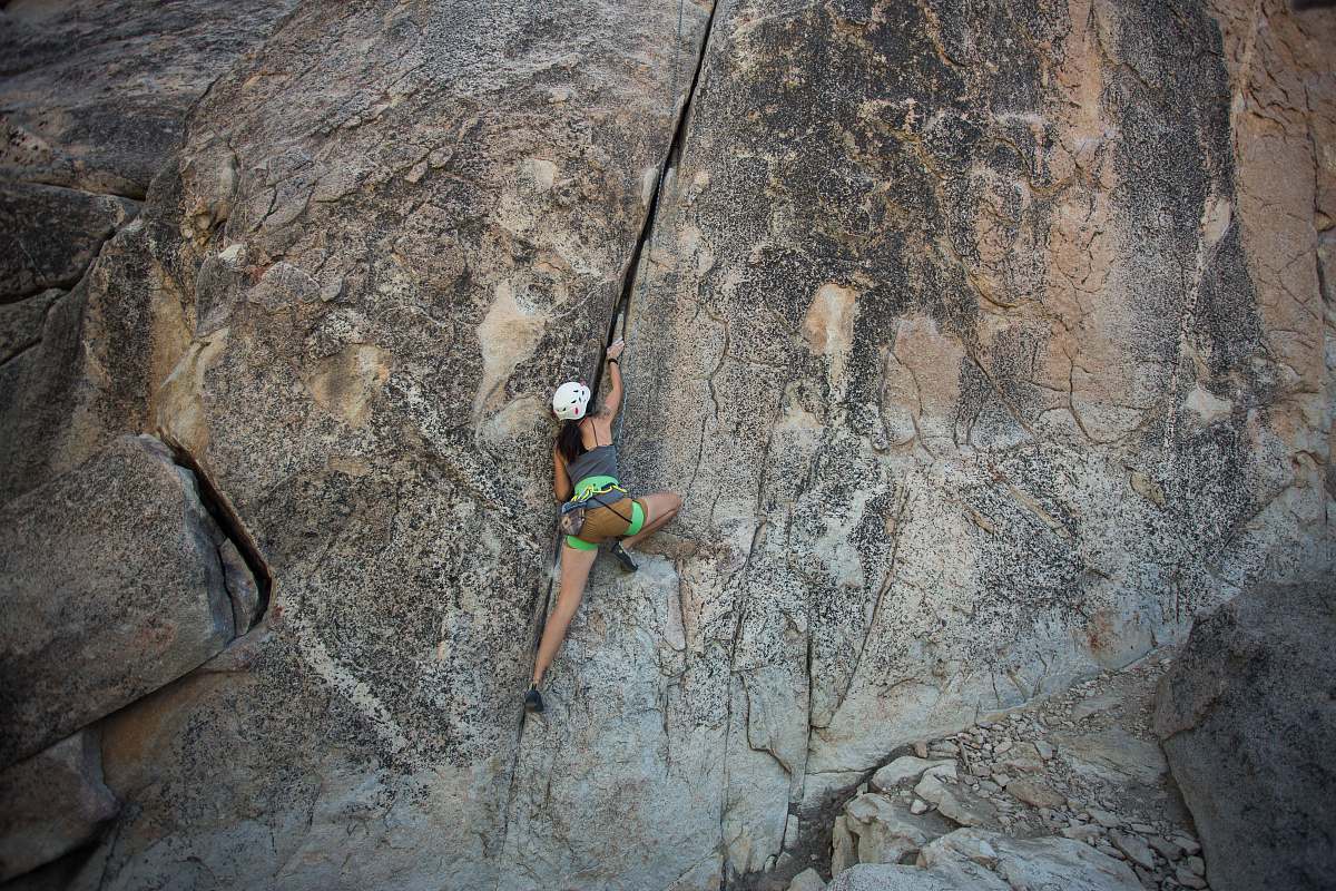 climbing woman climbing on rock cliff during daytime outdoors