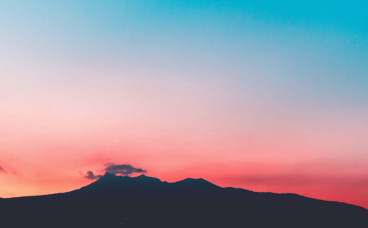sky silhouette of mountain under pink and blue skies gradient