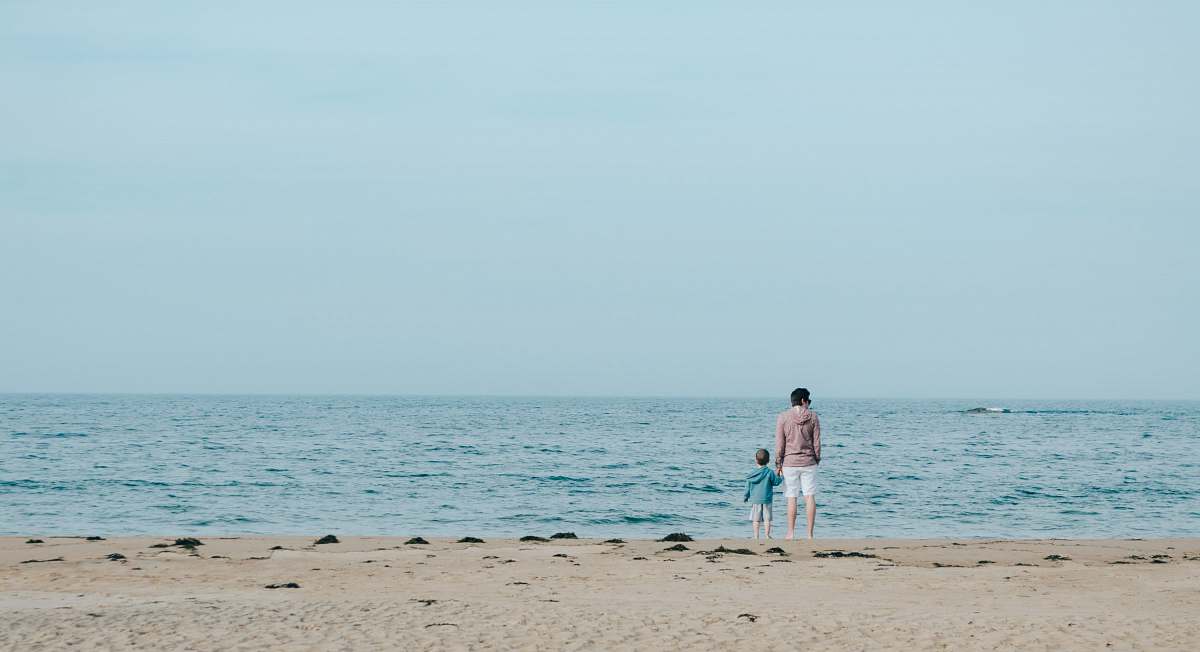 coast man and toddler standing on shore ocean