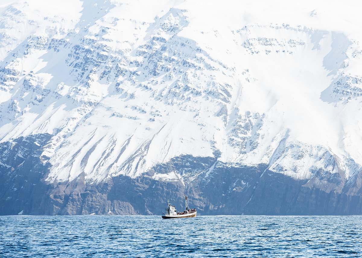 snow white boat on body of water bear mountain covered of snow mountain