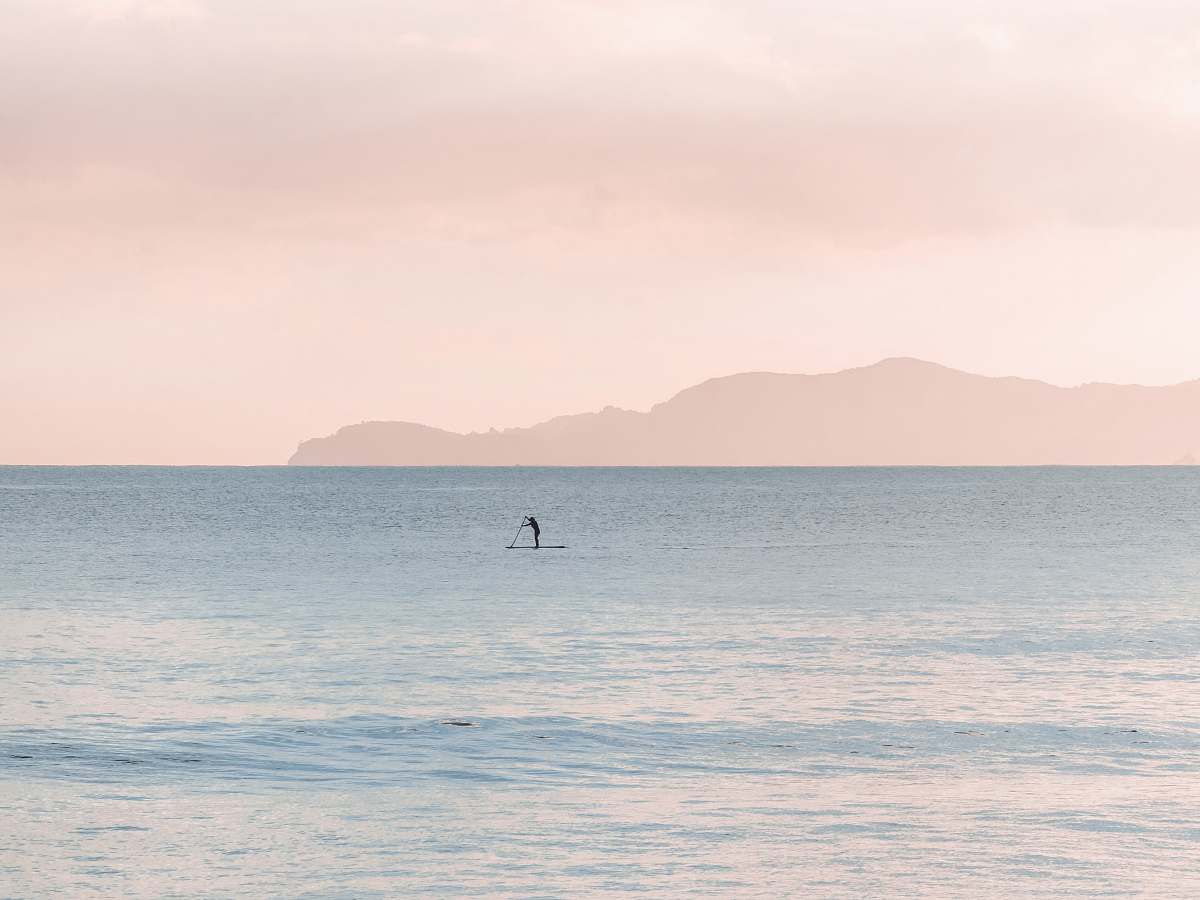 sea person paddle boarding during daytime pastel