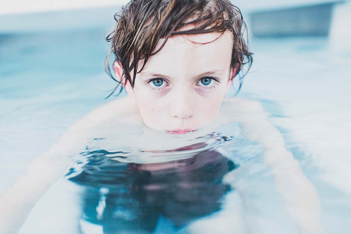 human selective focus photography of boy floating on water kid