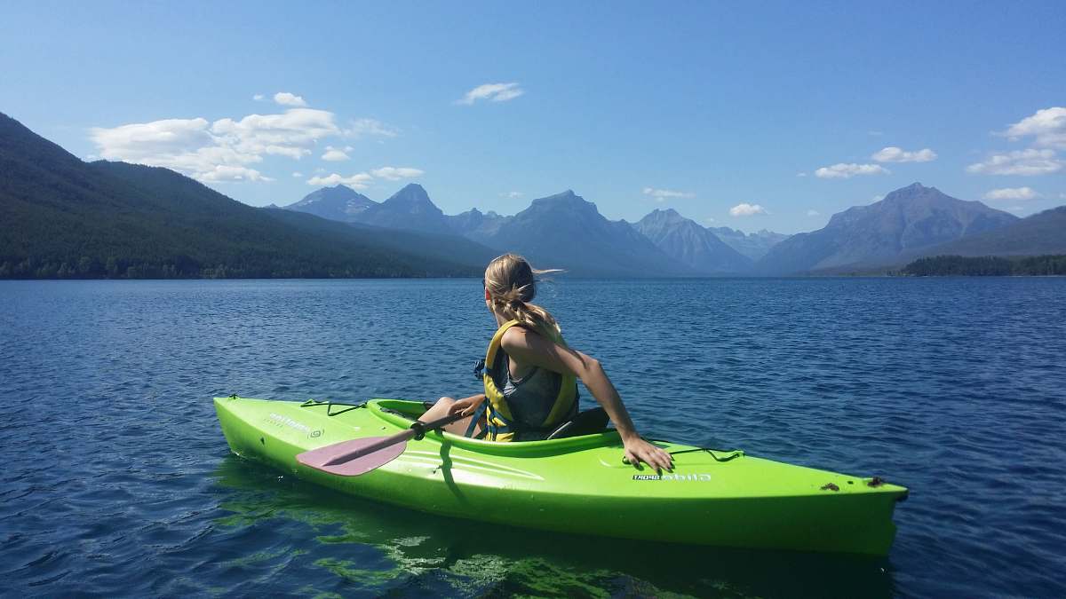 canoe woman on kayak in the middle of body of water people