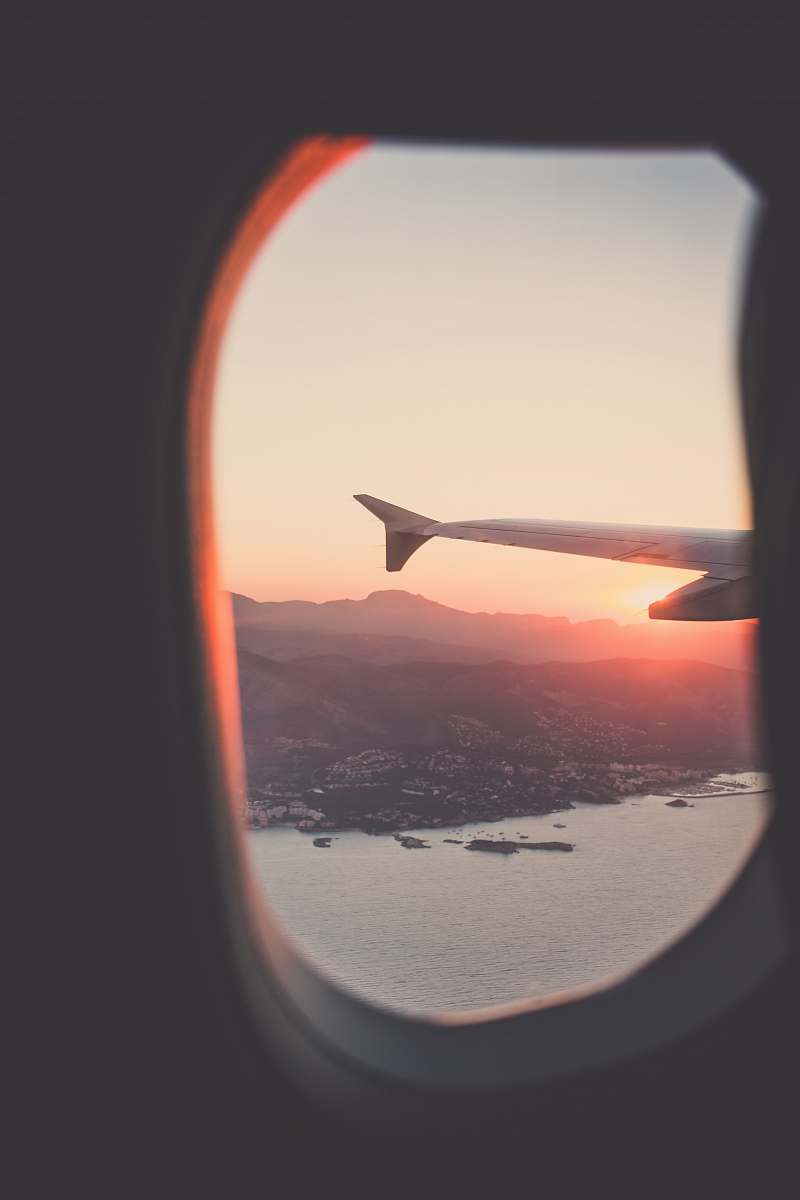 Capture the essence of travel with this breathtaking photograph of a person riding an airplane during sunset. The mesmerizing view from the airplane window showcases a vibrant sunset casting golden hues over the tranquil ocean. Perfect for travel blogs, tourism brochures, and inspiration for wanderlust enthusiasts, this image conveys the freedom and beauty of exploring the skies.