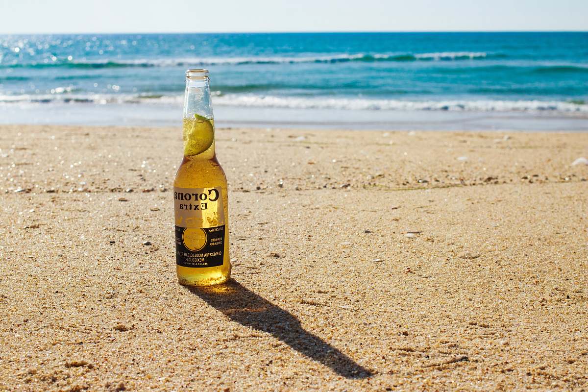 beer Corona Extra bottle on seashore during daytime bottle