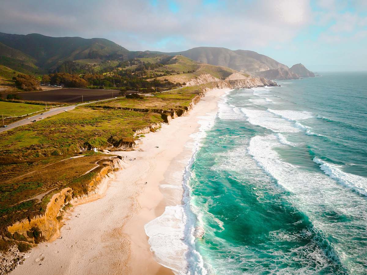coast aerial photo of body of water during daytime sand