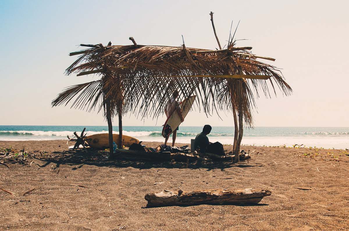 sea man reclining under hut on seashore costa rica