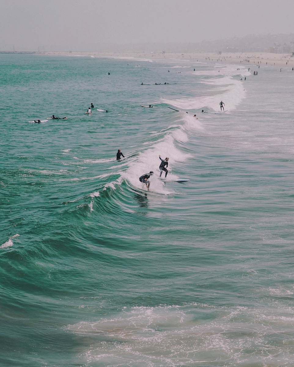 grey people surfing on ocean waves venice beach