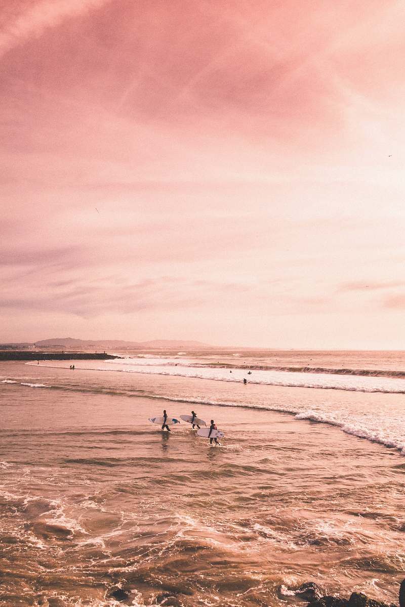 sea several people standing on seashore pink