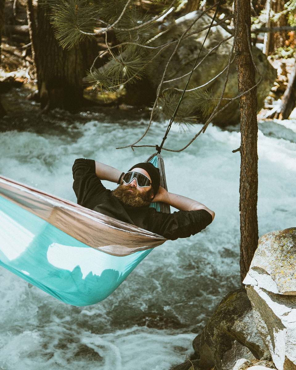 transportation man reclining on blue and brown hammock vessel