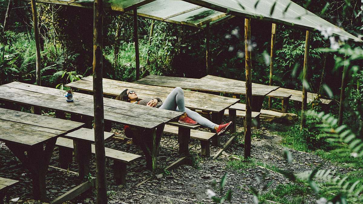 plant woman lying on gray wooden picnic table sleep
