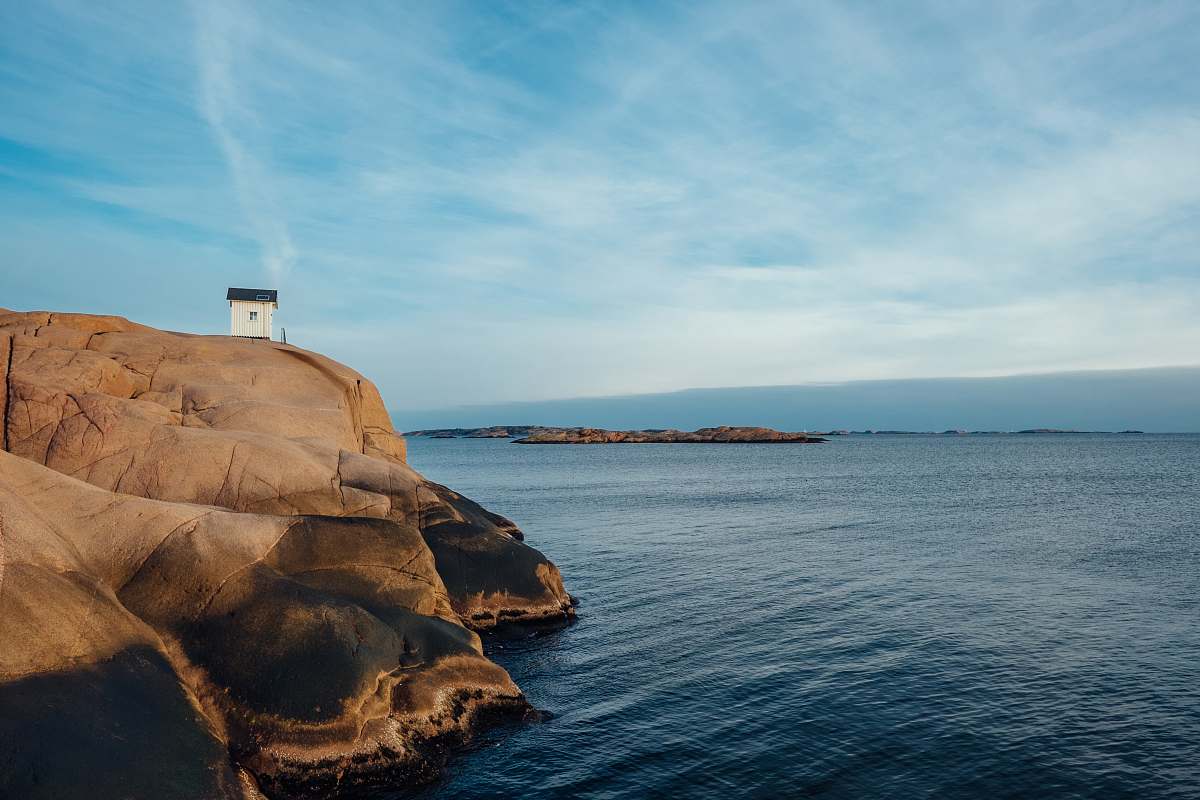 coast white concrete house on rock formation near sea at daytime ocean