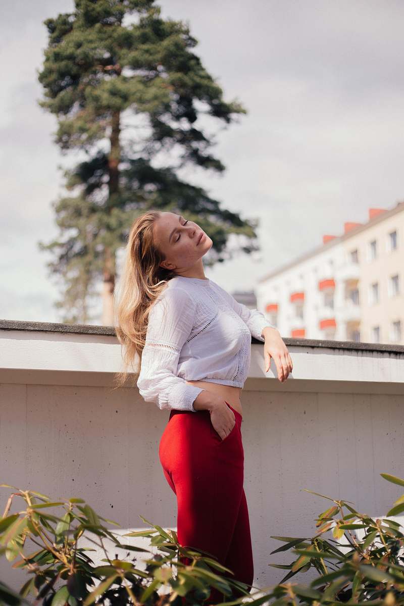 apparel woman wearing white long-sleeved crop-top and red pants during daytime sleeve