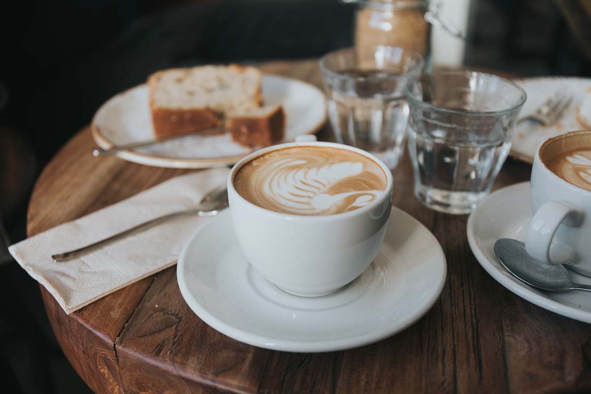 vienna white ceramic mug on white ceramic saucer on brown wooden table saucer
