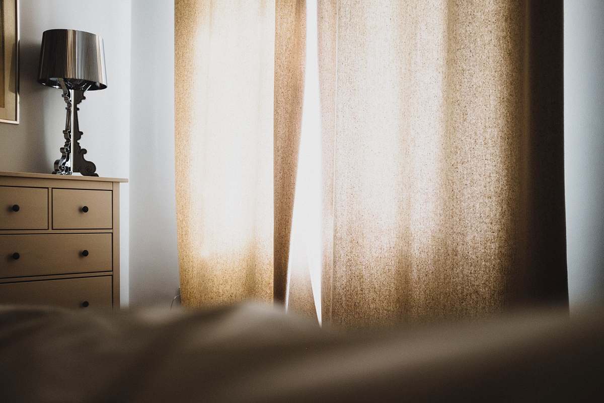 bed brown window curtain near dresser and table lamp home decor