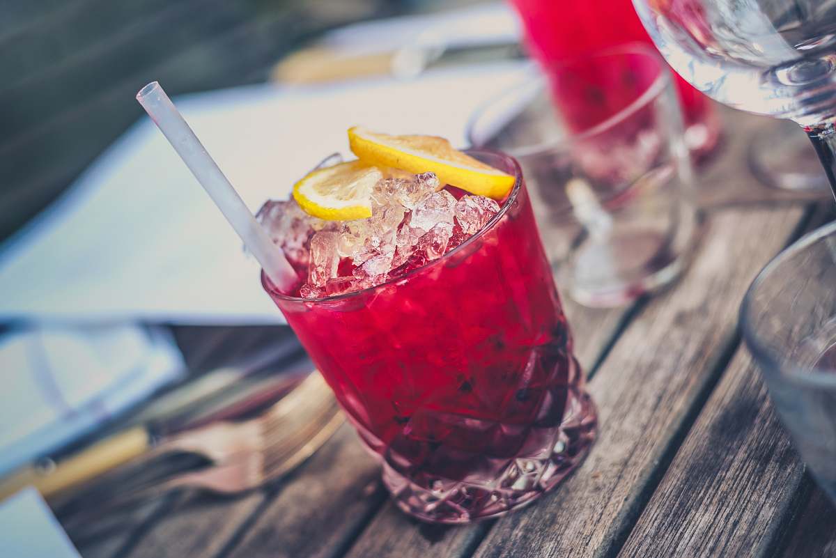 beverage clear drinking glass with red wine and straw cocktail