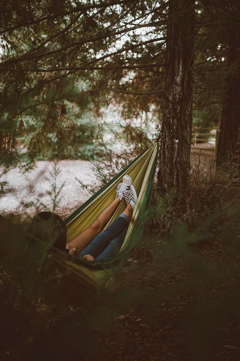 camping person on yellow hammock hanging on tree people