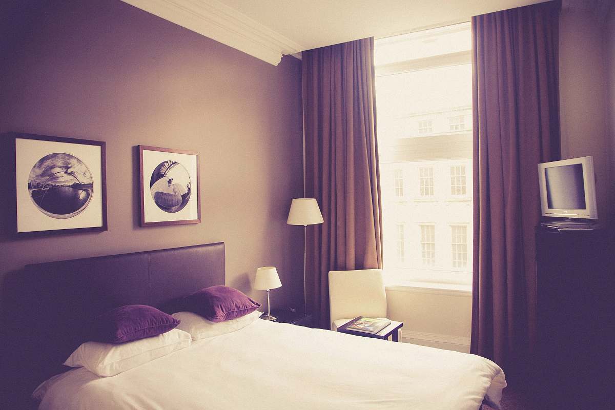 bed white bed comforter near table lamp tv