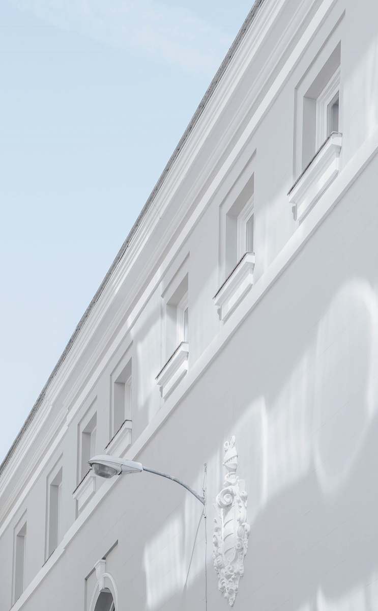 spain white street lamp mounted on white building wall corner