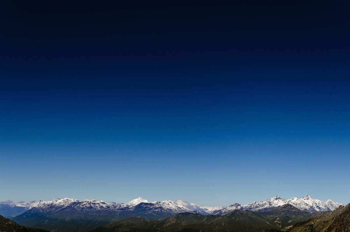 blue aerial photo of snow covered mountain sky