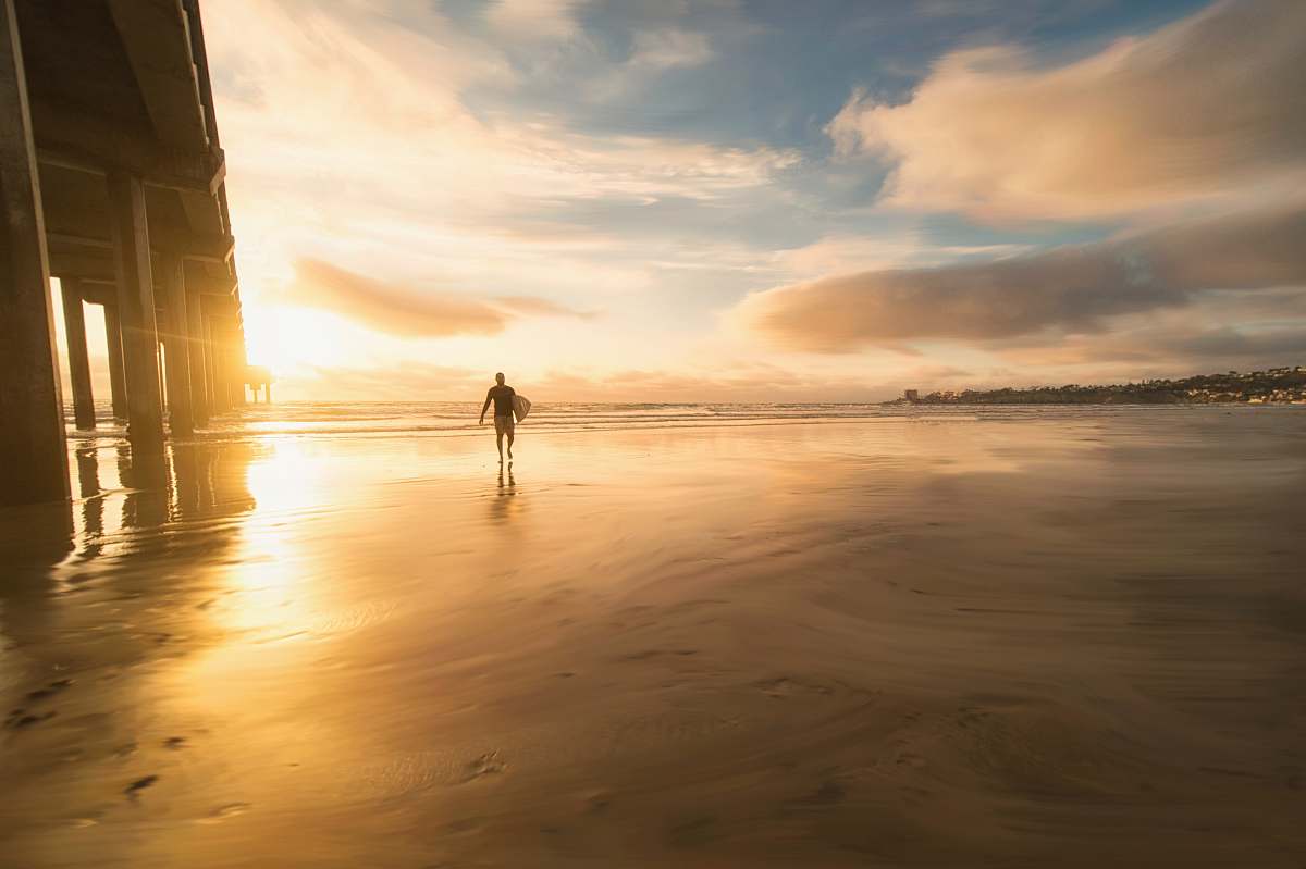 beach person walking under bridge san diego