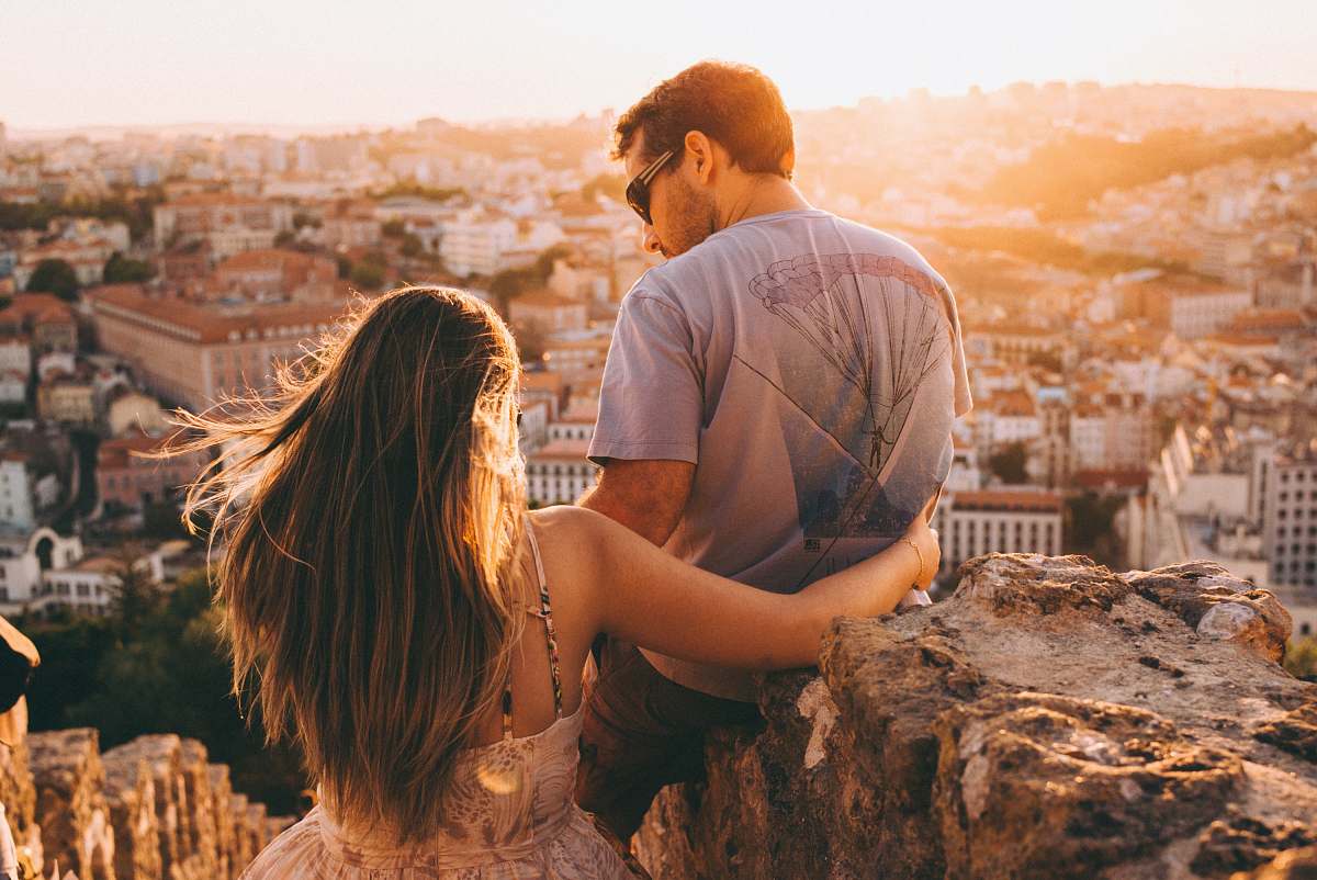 human man and woman on top of cliff couple