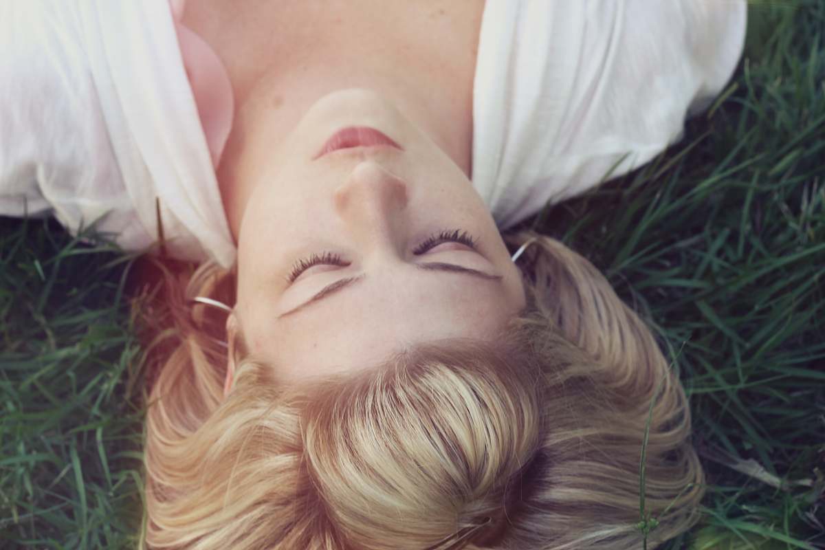 human woman lying on green grasses woman