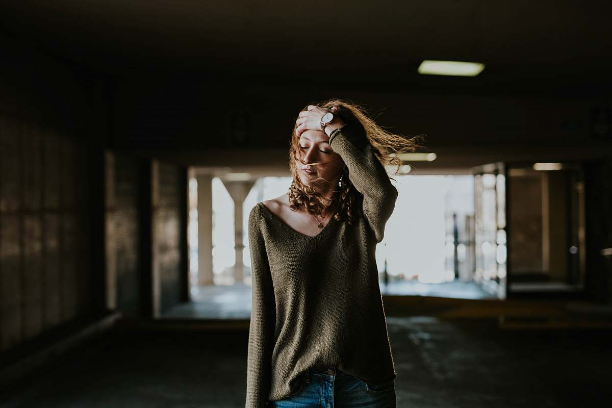 person woman walking oh street while holding forehead human