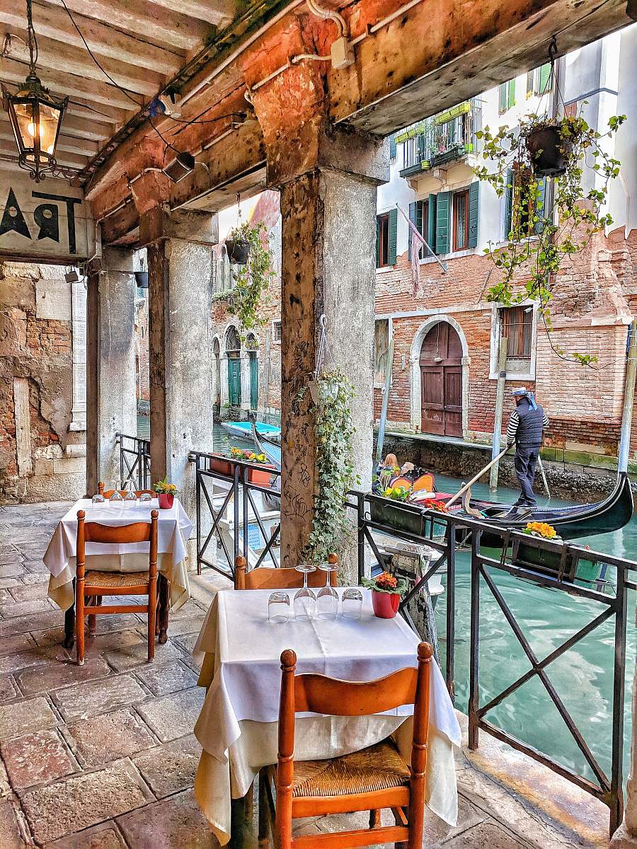 human man riding on boat beside restaurant restaurant