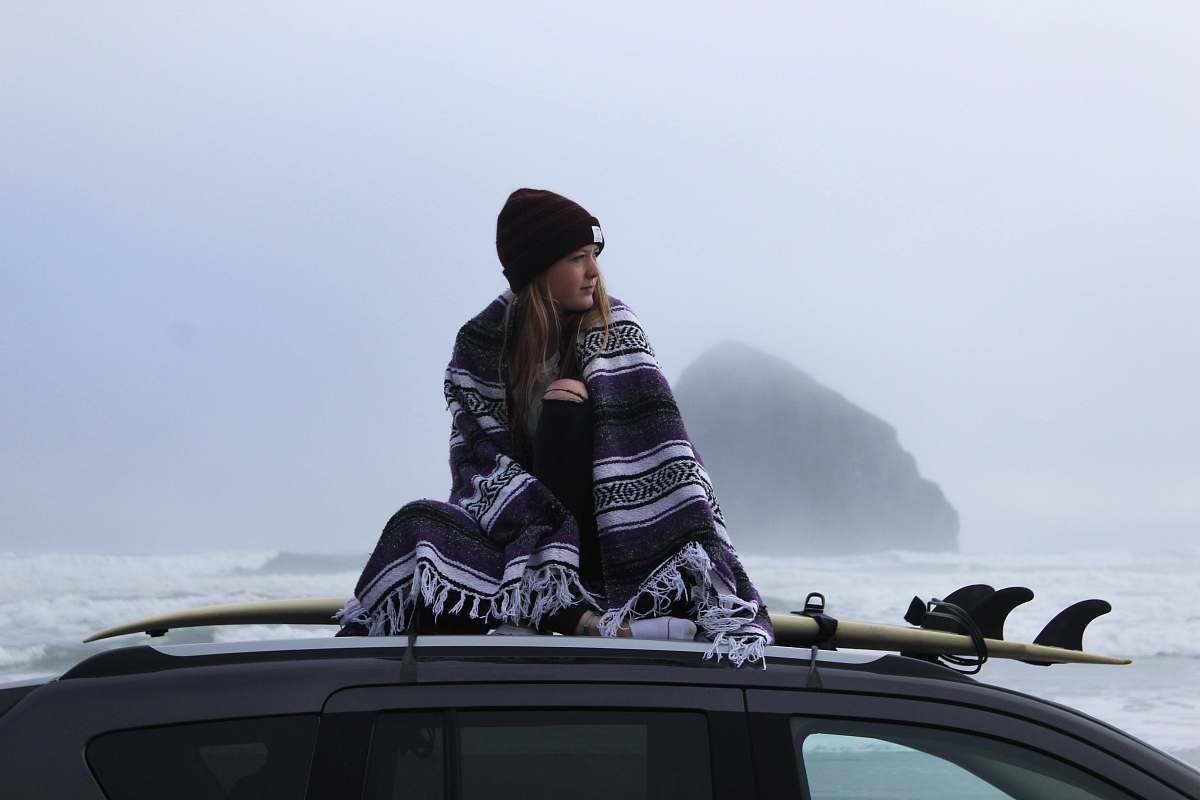 human woman wearing beanie hat on vehicle roof people